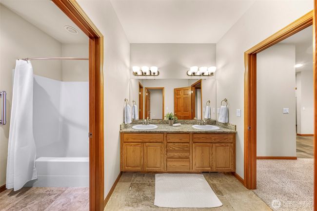 Full bathroom with double sinks accessed from a bedroom and living area | Image 25