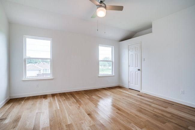Empty room featuring light wood-style flooring, lofted ceiling, baseboards, and ceiling fan | Image 22