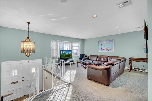 Carpeted living room featuring an inviting chandelier | Image 7