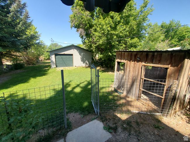 View of yard featuring an outdoor structure, a garage, and exterior structure | Image 14