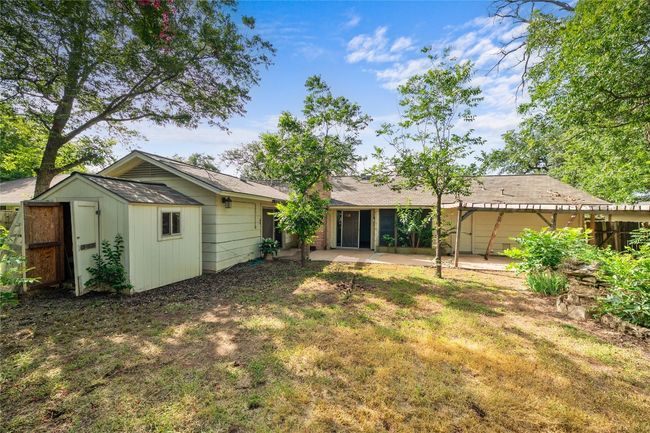 Rear view of property featuring a patio area, a yard, and a storage unit | Image 14