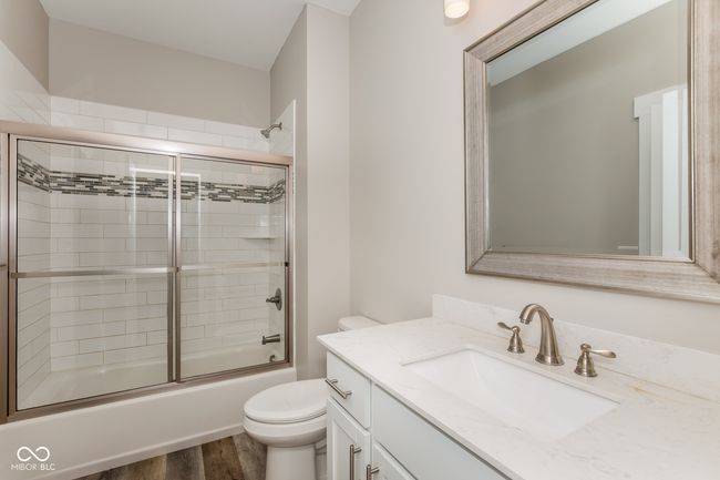 full bath with toilet, vanity, wood finished floors, and shower / bath combination with glass door | Image 6