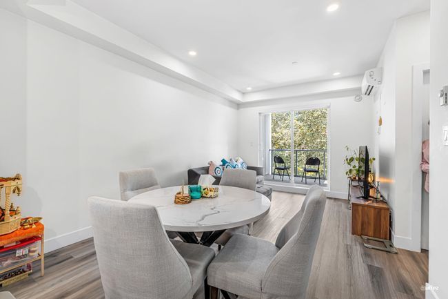Dining area with a wall mounted AC, wood finished floors, and recessed lighting | Image 7