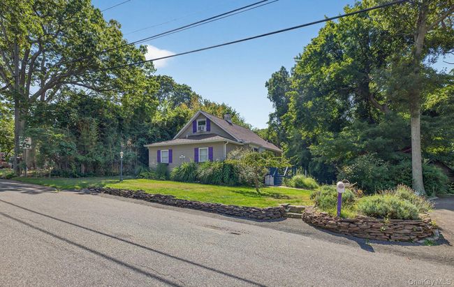 View of front of property with a front lawn, a chimney, and view of wooded area | Image 25