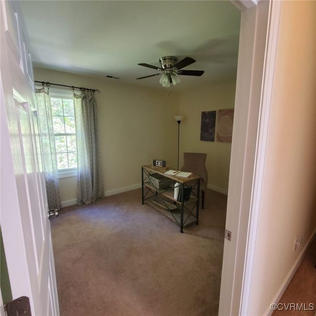 Home office featuring visible vents, baseboards, a ceiling fan, and carpet flooring | Image 46