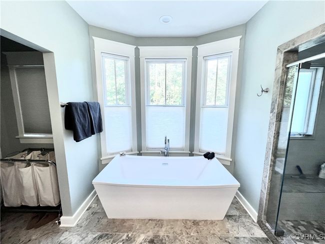 Full bath featuring healthy amount of natural light, a freestanding tub, and a shower stall | Image 33