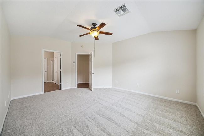 Step into your private haven —the primary bedroom and full bathroom blending comfort and neutral tones [with fresh new paint and carpet (May 2025)], high ceilings, and natural light from the primary bedroom window. It’s the perfect backdrop for your designer touches and personal flair. | Image 15