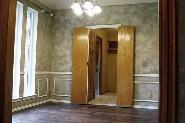 Unfurnished room with a chandelier, wood finished floors, and baseboards | Image 4