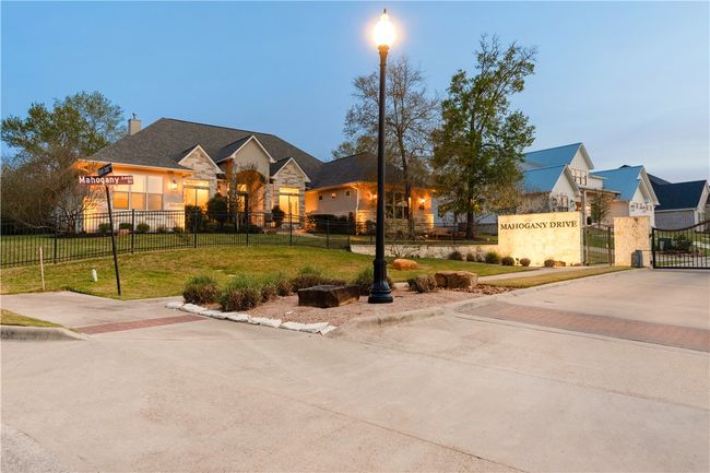 View of front facade with a front yard, fence, a gate, and stone siding | Image 35
