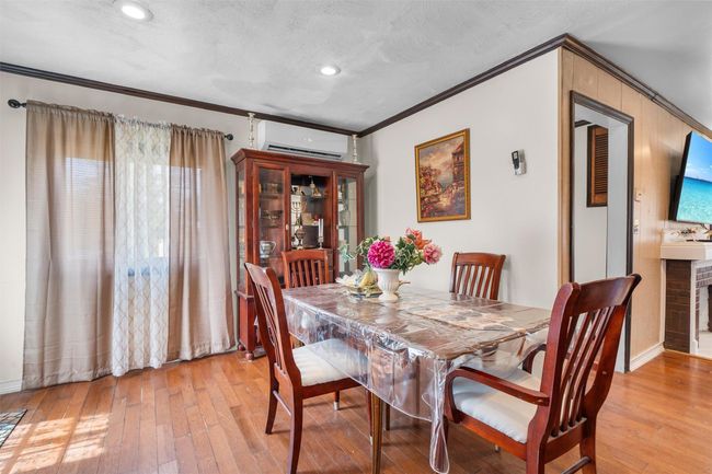 Dining space with a wall mounted AC, ornamental molding, light wood-type flooring, recessed lighting, and baseboards | Image 10