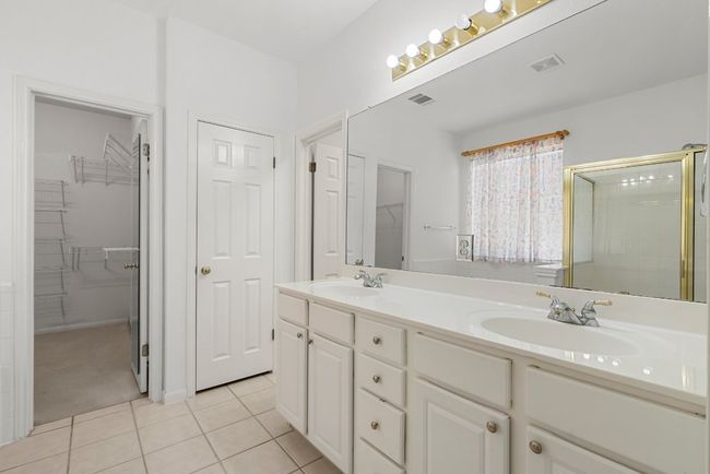 Full bathroom featuring tile patterned flooring, double vanity, visible vents, and a sink | Image 12