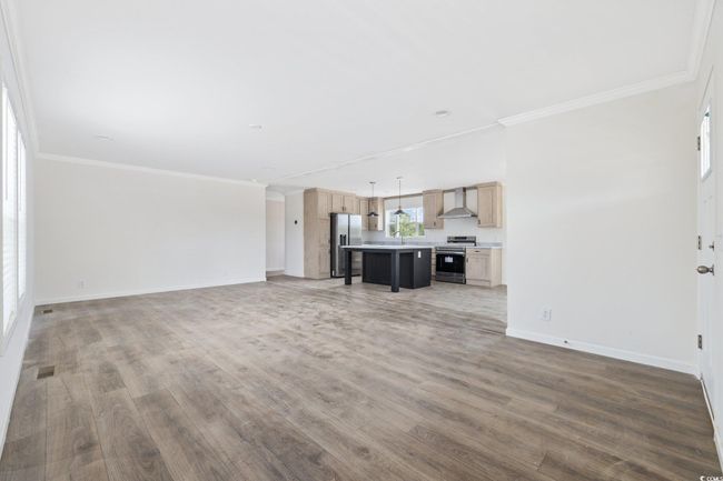 Unfurnished living room with light wood-type flooring and crown molding | Image 10