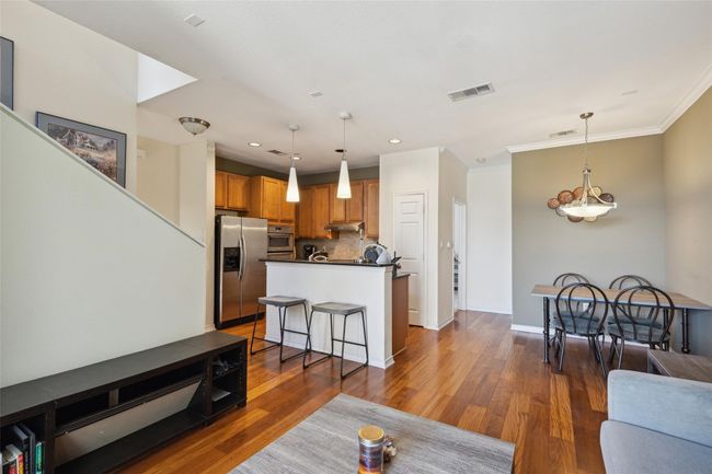 Living area featuring wood finished floors, ornamental molding, recessed lighting, and baseboards | Image 6