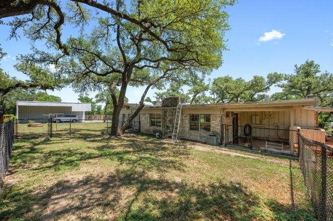 Rear view of property featuring stone siding, a gate and fenced portion right off home | Image 27