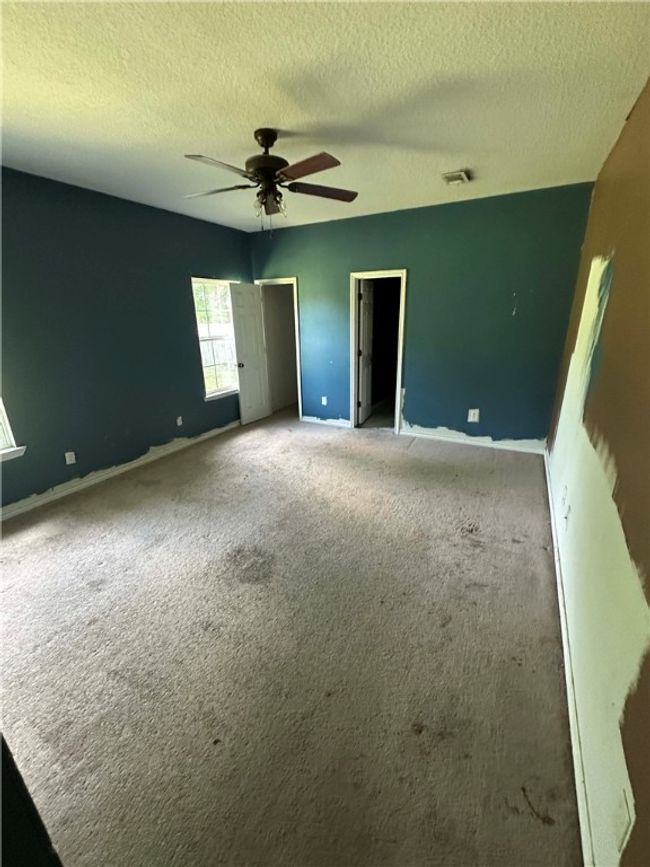 Unfurnished bedroom featuring carpet, a textured ceiling, and a ceiling fan | Image 8