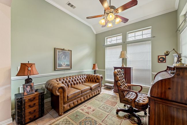 Office space with crown molding, tile patterned floors, a ceiling fan, and baseboards | Image 10