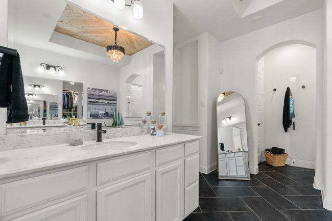 Bathroom with wooden ceiling, vanity, tile patterned flooring, a chandelier, and baseboards | Image 19