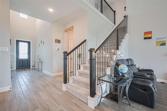 Welcoming entryway with wood-look tile flooring and elegant wall accents | Image 7