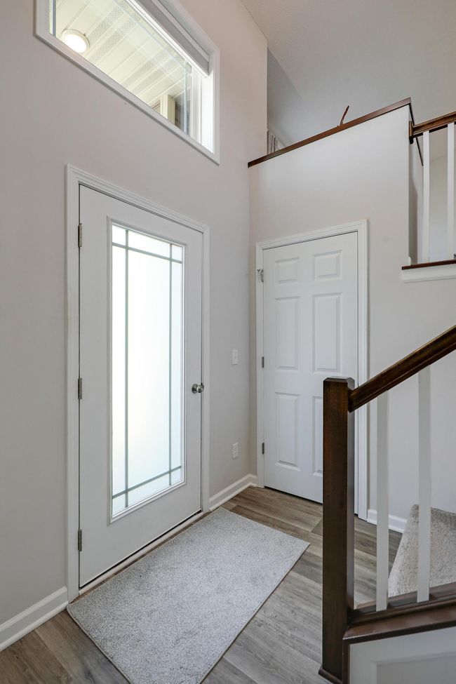 Step into a spacious front entry featuring a stunning transom window above the door, flooding the space with natural light an creating a bright, welcoming atmosphere from the moment you walk in. | Image 5