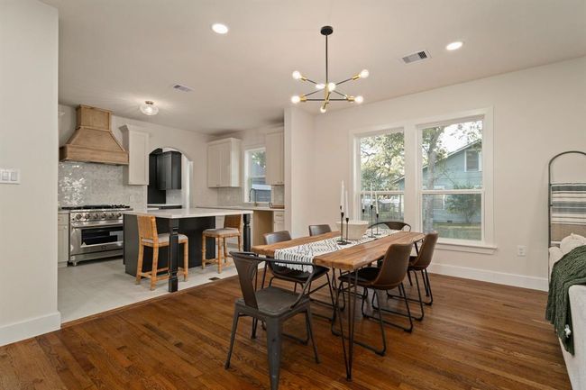 Large windows centered on the wall flood the dining room with natural light. | Image 11