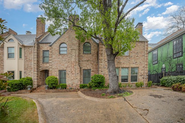 View of front of property featuring brick siding, fence, and a chimney | Image 18