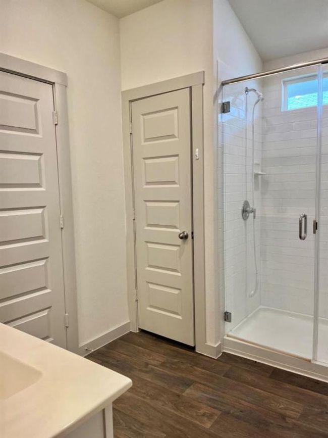 Full bath featuring wood finished floors, a stall shower, vanity, and baseboards | Image 16