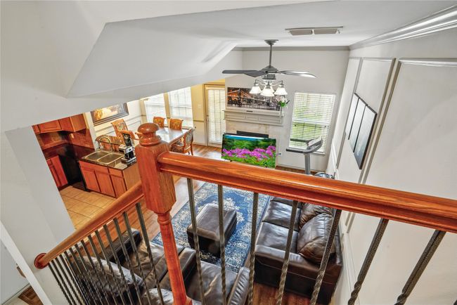 Stairway featuring vaulted ceiling, a fireplace, ceiling fan, and wood finished floors | Image 18