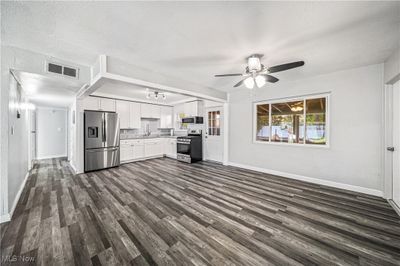 Unfurnished living room with a textured ceiling, ceiling fan, sink, and dark hardwood / wood-style flooring | Image 3