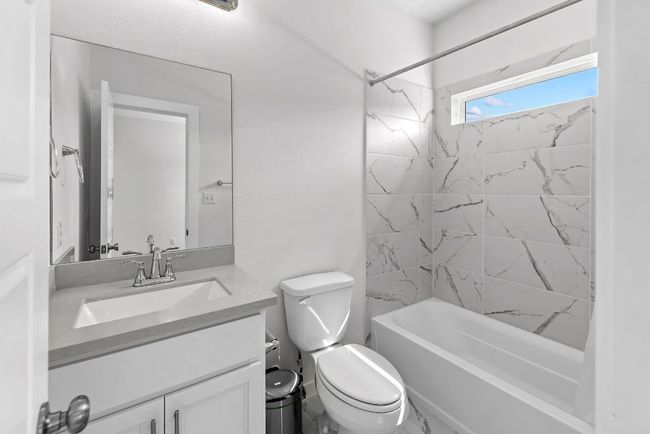 Bathroom with toilet, vanity, and tub / shower combination | Image 30