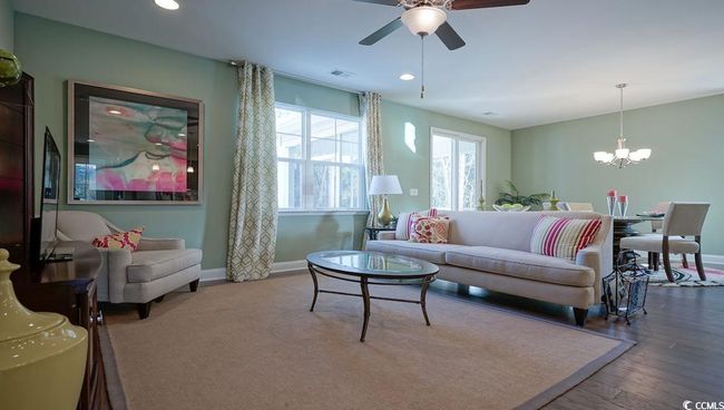 Living room featuring ceiling fan, wood finished floors, a chandelier, baseboards, and recessed lighting | Image 11