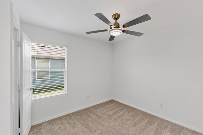 Unfurnished room with light colored carpet, baseboards, and a ceiling fan | Image 25