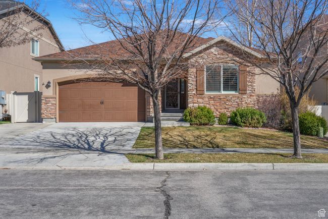 View of front of property with stucco siding, an attached garage, stone siding, and concrete driveway | Image 36