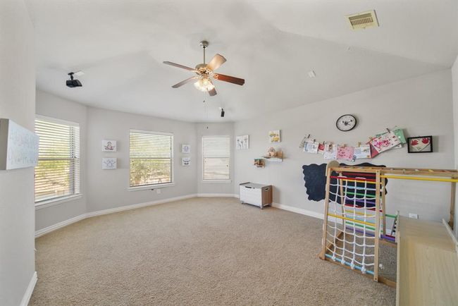 Located on the second level of the home is a spacious game room with windows & blinds overlooking the backyard. | Image 27