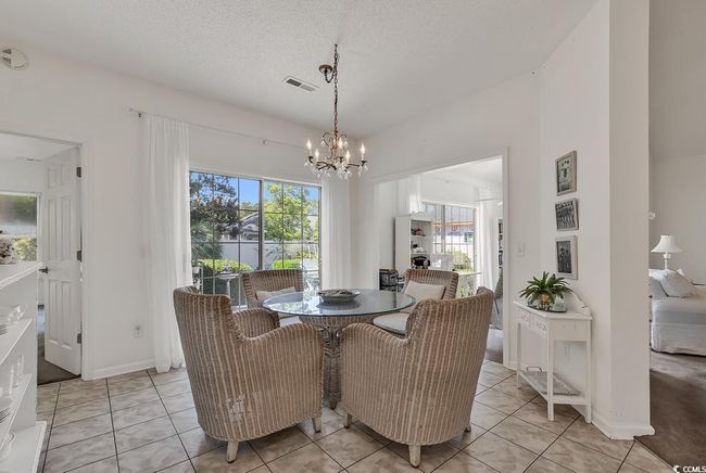 Dining room with healthy amount of natural light, a chandelier, light tile patterned floors, and a textured ceiling | Image 17