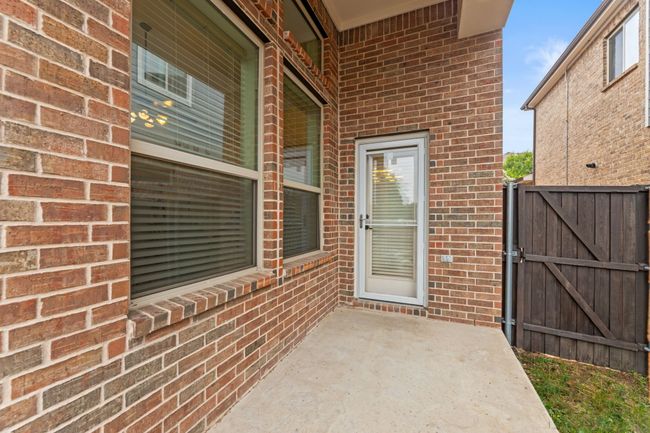 View of exterior entry featuring a gate and brick siding | Image 33
