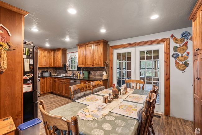 Kitchen featuring wood finished floors, french doors, recessed lighting, and brown cabinetry | Image 8