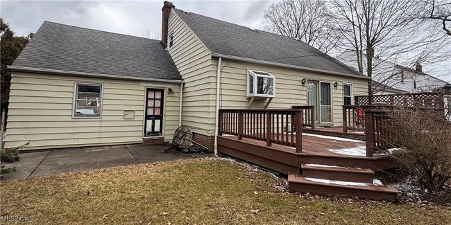 Rear view of property with a yard, a wooden deck, a chimney, and roof with shingles | Image 28