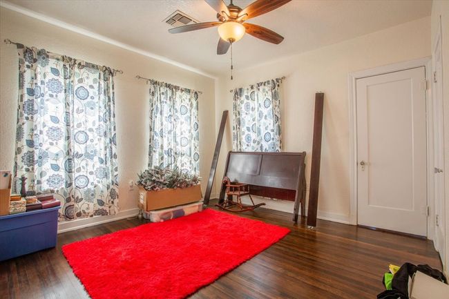 Living area featuring wood finished floors, visible vents, a ceiling fan, and baseboards | Image 26