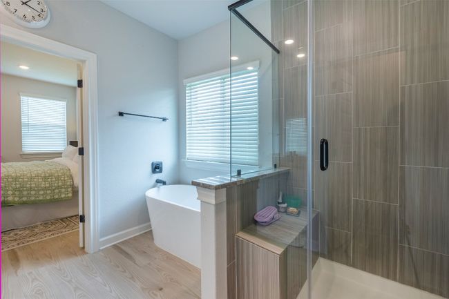Ensuite bathroom with wood finished floors, a freestanding bath, a shower stall, and healthy amount of natural light | Image 19
