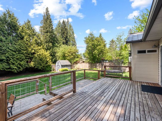 Wooden deck featuring a shed and an outdoor structure | Image 32