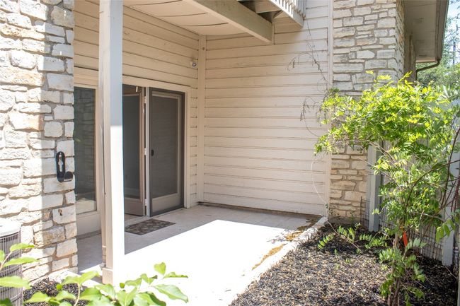 Doorway to property featuring central air condition unit and stone siding | Image 13