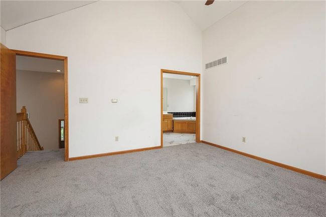 Unfurnished room with high vaulted ceiling, light carpet, baseboards, and ceiling fan | Image 18