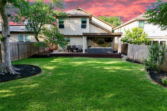 Back of property at dusk with an outdoor living space, board and batten siding, and a wooden deck | Image 25