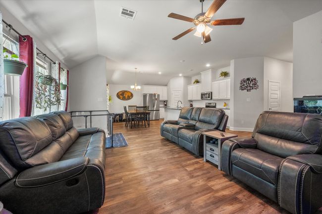 Living area with a ceiling fan, wood finished floors, lofted ceiling, and recessed lighting | Image 7