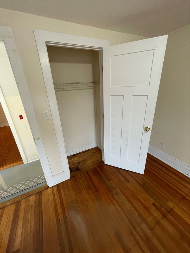 Unfurnished bedroom with wood-type flooring, baseboards, and a closet | Image 8