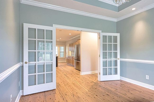 Spare room featuring crown molding, a chandelier, light wood finished floors, french doors, and recessed lighting | Image 7