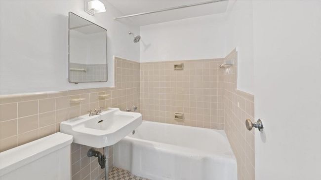 Full bath with toilet, bathtub / shower combination, and tile walls | Image 7