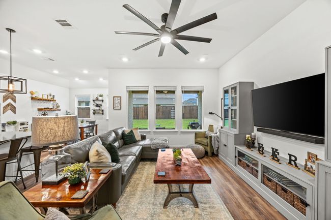 Living area featuring wood finished floors, a ceiling fan, and recessed lighting | Image 6