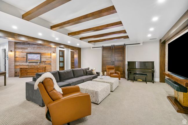 Living room featuring wood walls, carpet flooring, recessed lighting, and a barn door | Image 78