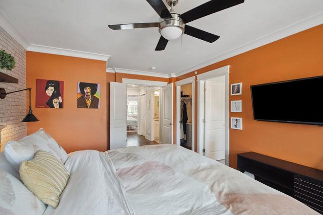 Bedroom with a ceiling fan, brick wall, ornamental molding, and a walk in closet | Image 17